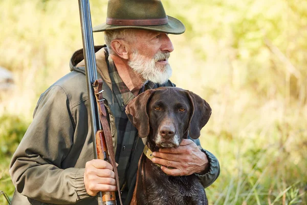 Senior cazador con perro en el bosque —  Fotos de Stock