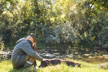 Sahibi ile gölde avlanan bir köpek.