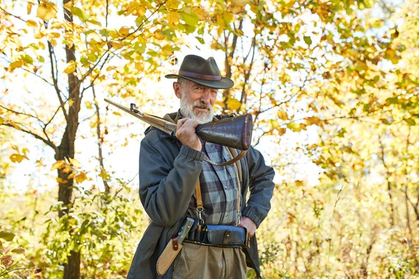 Caçador sênior carrega arma de rifle no ombro — Fotografia de Stock