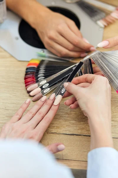 Manos de mujer de cerca. Elegir el color de las uñas derecha —  Fotos de Stock