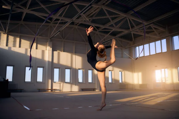 Jeune femme mignonne en costume de gymnaste montrer des compétences athlétiques — Photo