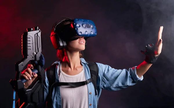 Giovane donna con occhiali di realtà virtuale utilizzando l'arma — Foto Stock