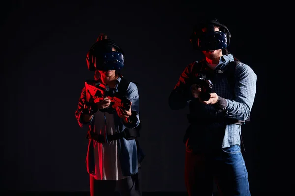 Fantastique jeu virtuel. Les jeunes couples jouent avec des lunettes, des casques et des armes — Photo