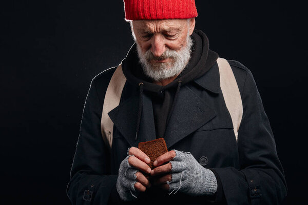 Poor homeless man holding piece of bread