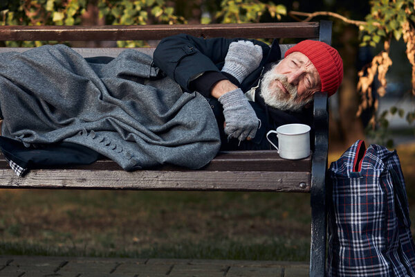 Poor vagrant on bench