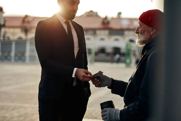 Rich man help senior beggar — Stock Photo, Image
