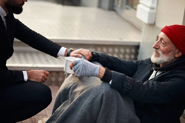 El mendigo se sienta en la calle y necesita ayuda. — Foto de Stock