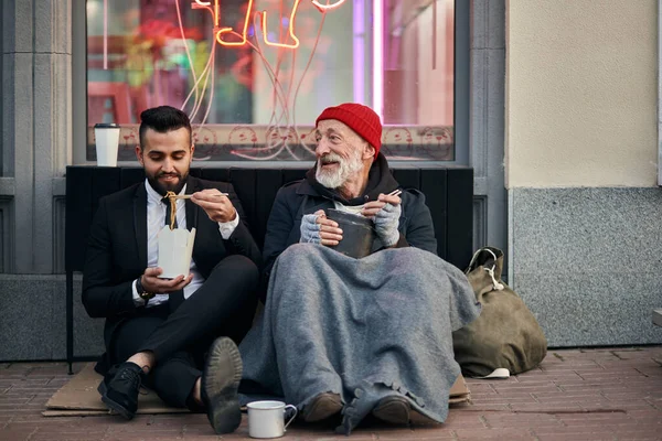 Trabajador de oficina sentado con mendigo en la calle — Foto de Stock