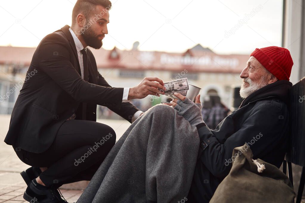 Gentle man in tuxedo help homeless man