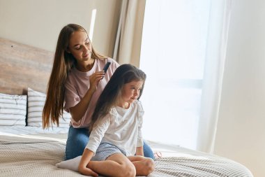 Nazik anne saç stili yapıyor.