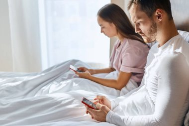 Genç çift, ebeveynleriyle cep telefonu kullanarak mesajlaşıyor.