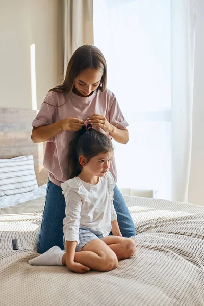 Giovane madre pettinando bambino — Foto Stock