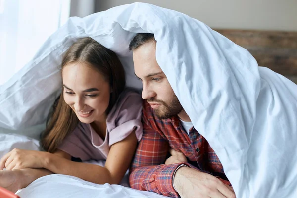 Boldog pár fehér takaró alatt — Stock Fotó