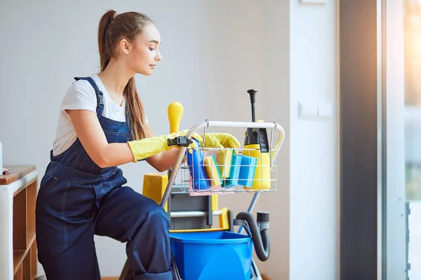 Zijaanzicht op aantrekkelijke vrouwelijke reiniger — Stockfoto