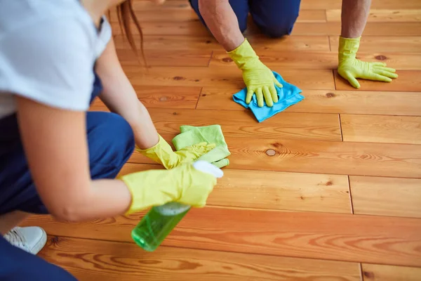 Mãos no chão de limpeza de luva protetora amarela com pano — Fotografia de Stock