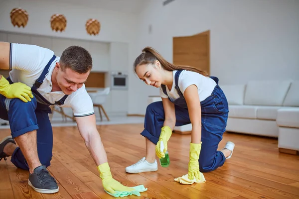 Twee conciërges reinigen vloer met doek op een witte achtergrond — Stockfoto