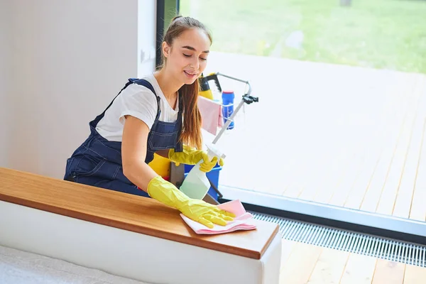 Petugas kebersihan wanita yang energik membersihkan kamar — Stok Foto