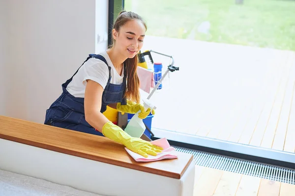 Energetische vrouwelijke conciërge opruimen kamer — Stockfoto