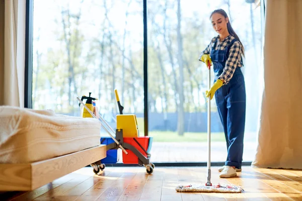 Fiatal takarító egyenruhában a padló felmosásához — Stock Fotó