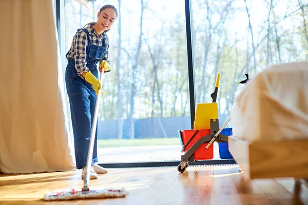Fiatal takarító egyenruhában a padló felmosásához — Stock Fotó