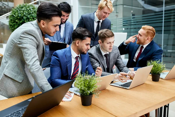 Team av upptagna unga affärsmän i möte på kontoret — Stockfoto