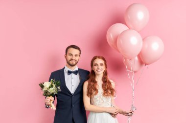 Pembe üzerine izole edilmiş yeni evli beyaz çiftin portresi.