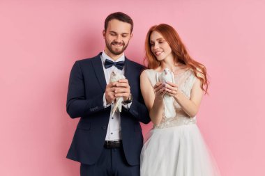 Yeni evli beyaz çift güvercin tutuyor.