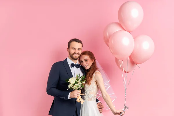 Retrato de novo casal caucasiano feliz isolado em rosa — Fotografia de Stock