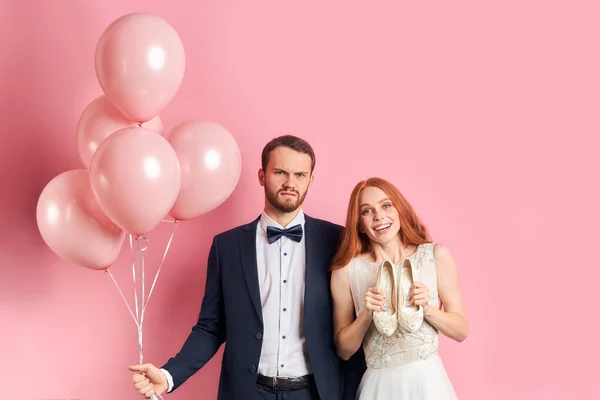Sctrict αρραβωνιαστικός και ευτυχισμένη νύφη απομονώνονται σε ροζ φόντο — Φωτογραφία Αρχείου