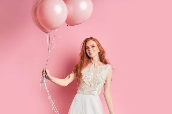 Sonriente hermosa mujer en vestido de novia con globos de aire rosa —  Fotos de Stock