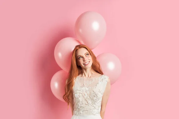 Encantadora dama mirando hacia arriba con globos de aire aislados sobre fondo rosa —  Fotos de Stock