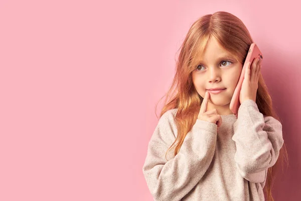Portré bájos aranyos édes lány okostelefon kezében elszigetelt rózsaszín háttér — Stock Fotó