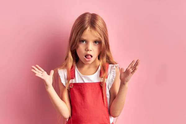 핑크 색 배경때문에 입을 벌리고 있는 웃긴 어린 소녀 — 스톡 사진