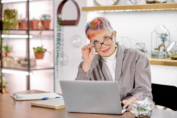 Business female sitting with laptop in light room