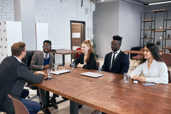 Міжнародна група бізнесменів сидять за столом — стокове фото
