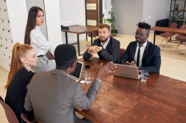 Rear view on african man speaking with colleagues