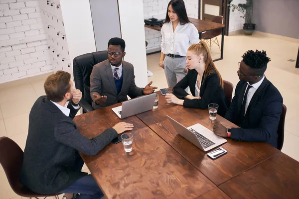 Jovem treinador de negócios africano conversando com jovens empresários — Fotografia de Stock