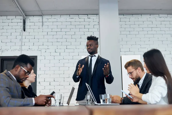 Serious african male leader or coach gives presentation of new business plan multi-ethnic meeting — Stock Photo, Image