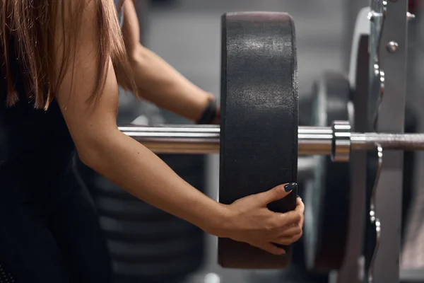 Close up of female hands fixing barbell — Stock Photo, Image