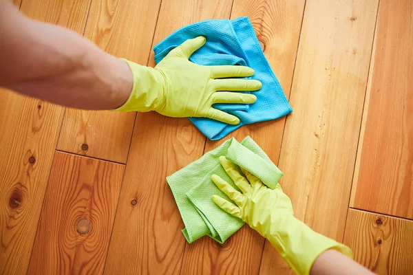 Manos en guante protector amarillo limpieza piso con trapo —  Fotos de Stock