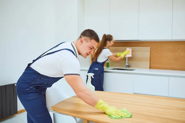 Úklidový tým při práci v kuchyni s bílým interiérem — Stock fotografie
