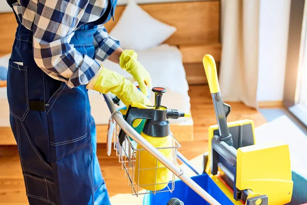 Bijgesneden shot reiniger in blauw uniform met reinigingsapparatuur — Stockfoto