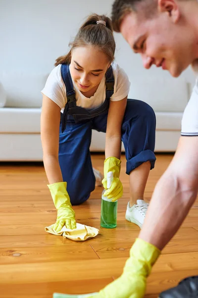 Zorgvuldige vrouwelijke schonere poetsvloer — Stockfoto