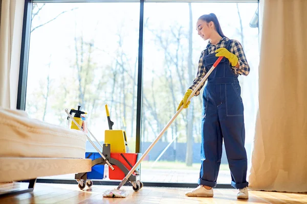 Piękna młoda kobieta sprzątanie podłogi w domu za pomocą mopa — Zdjęcie stockowe