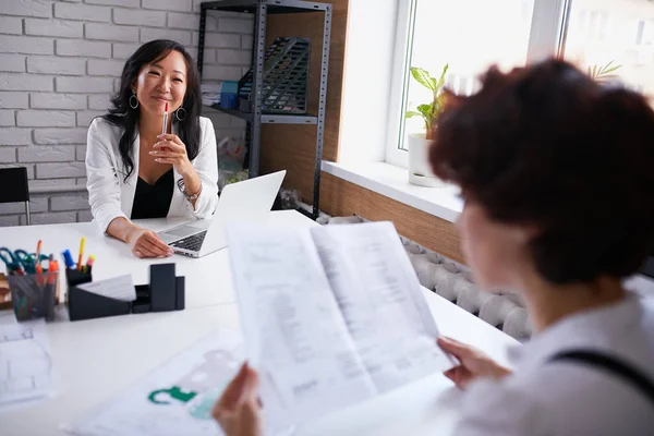 Young representative of caucasian company tell about company to asian — Stock Photo, Image