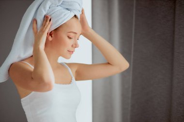 Kafasında havlu olan kadın duştan sonra dinleniyor.