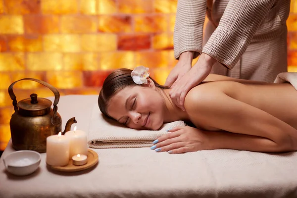 Caucásico masajista profesional haciendo masaje de mujer de vuelta en salón de belleza —  Fotos de Stock