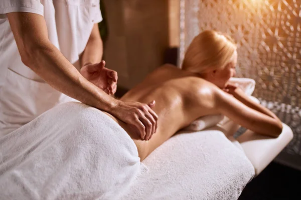 Masajista haciendo masaje en el cuerpo de la mujer en el salón de spa — Foto de Stock