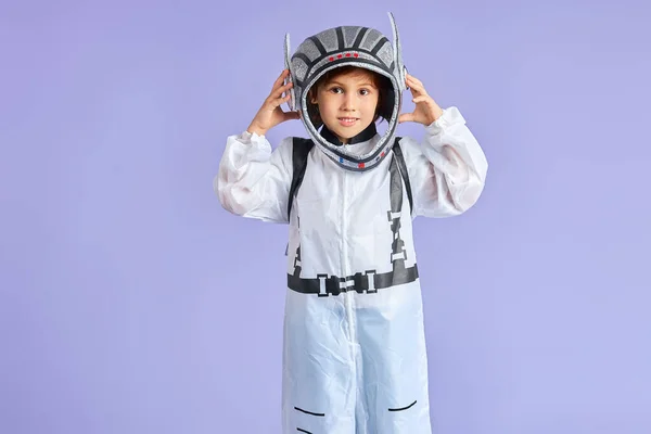 Retrato de un lindo astronauta niño con traje protector blanco y casco mirando a la cámara — Foto de Stock