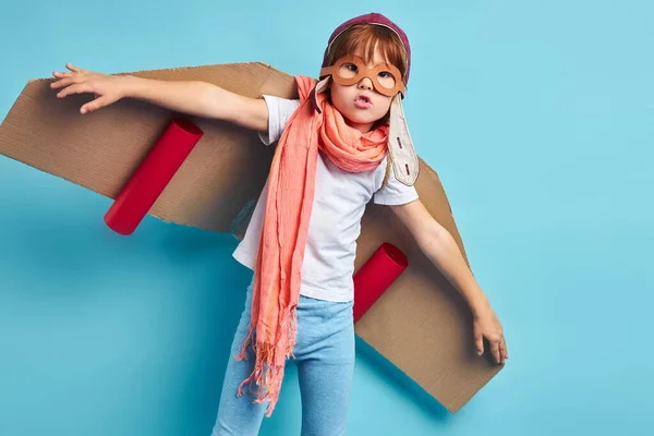 Piloto niño con plano de cartón aislado sobre fondo azul — Foto de Stock